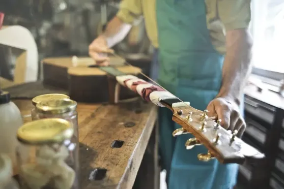 Luthier Ozan Telli, atölyede gitar üzerinde çalışırken